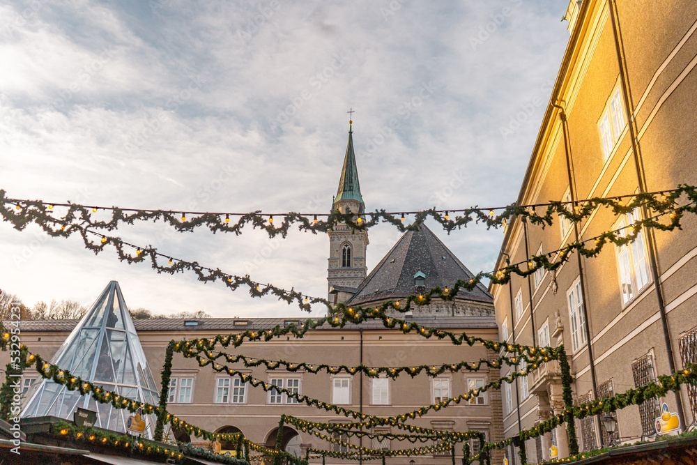 Naklejka premium Domplatz or Cathedral square and Christmas market in old town of Salzburg during winter : Salzburg , Austria : December 9 , 2019