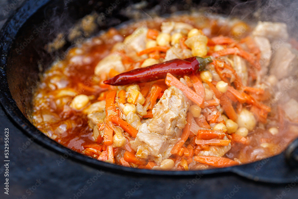 Cooking pilaf in a saucepan or cauldron. Pilaf is prepared on an open fire. Cooking pilaf in a saucepan or cauldron. Pilaf is prepared on an open fire.