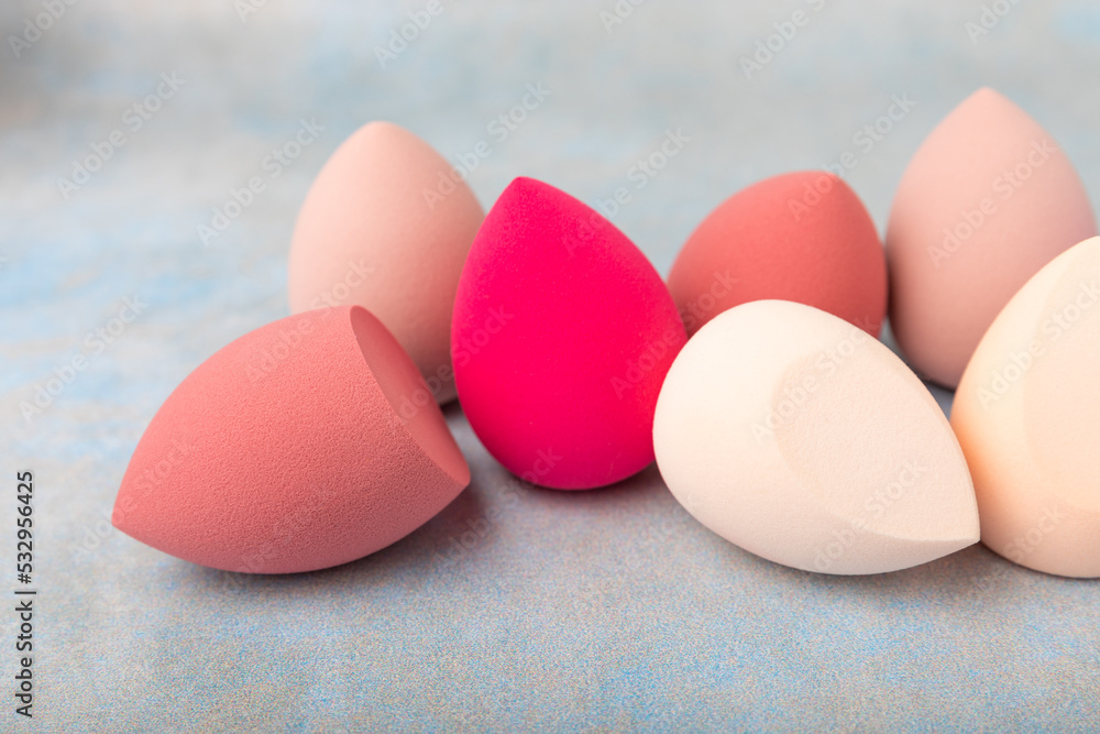 Beauty blender.Colorful beauty sponges on blue background. Cosmetic tool for applying and blending products such as foundation and concealer. Copy space. place for text. Beauty blender.Colorful beauty sponges on blue background. Cosmetic tool for applying and blending products such as foundation and concealer. Copy space. place for text.