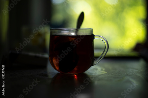 Tea in glass. Tea in morning. Transparent cup on table. Breakfast at dawn.