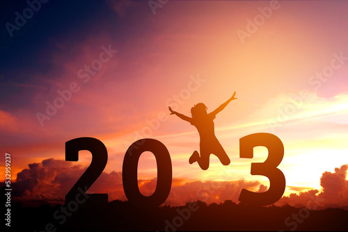 Silhouette young woman jumping to 2023 new year