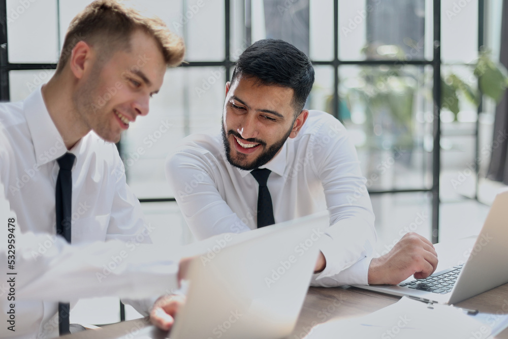 Two happy men working together on a new business project Two happy men working together on a new business project