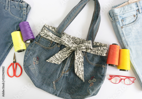 Denim bag and sewing accessories on white background , top view , recycle concept