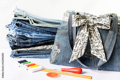 Old jeans and denim bag with sewing accessories. Recycle concept. Crafting with denim