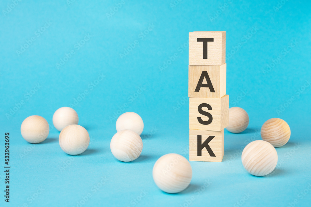 TASK - text on wooden block with bright blue background TASK - text on wooden block with bright blue background