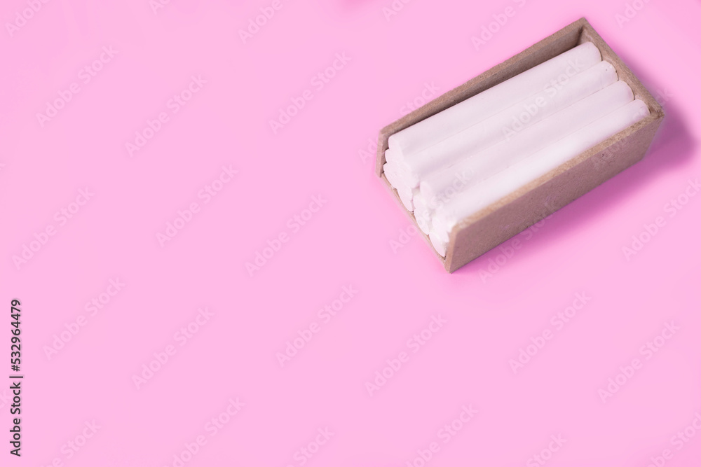 white chalk for writing on the board in brown wooden box on a pink background white chalk for writing on the board in brown wooden box on a pink background