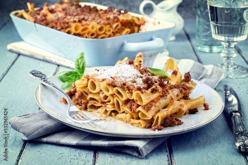 Traditional Italian candele alla marcinata pasta with miced meat and parmesan cheese served as close-up on a classic white plate photo