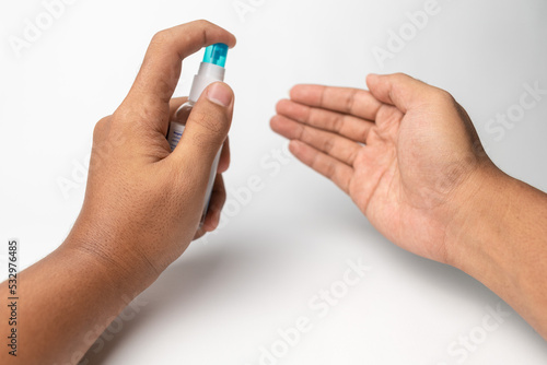man hands using spray hand sanitizer for cleaning his hands from virus isolated on white background