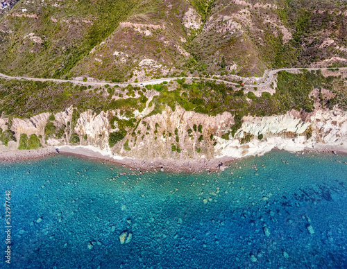 Aerial view of crystal clear water by the rocky shore in Sardinia