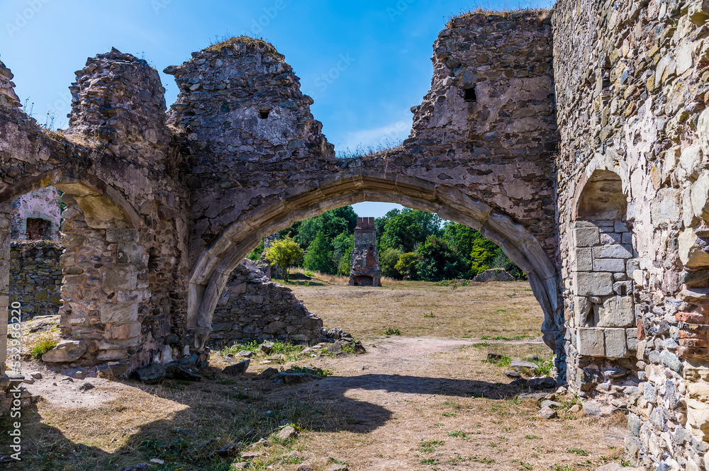 A view through an arch into the haunted ruins of Grace Dieu Priory in Leicestershire, UK in summertime