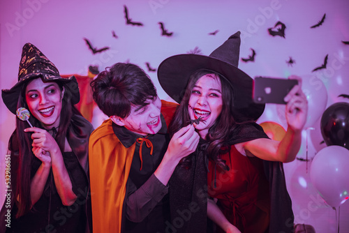 Asian young people in costumes celebrating halloween. Group of friends having fun at party in nightclub.
