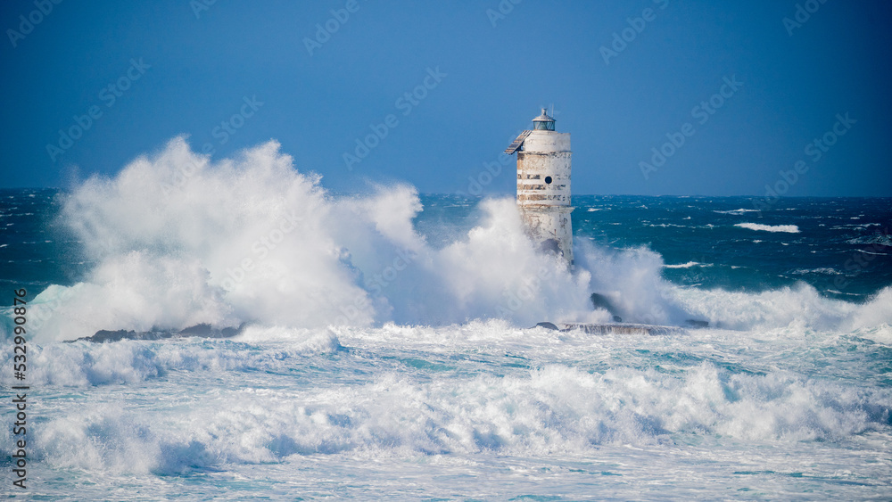 The lighthouse of the Mangiabarche shrouded by the waves of a mistral wind storm
