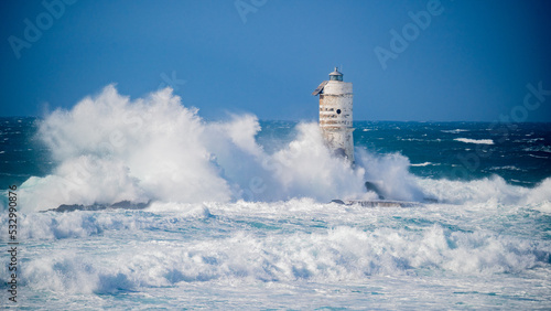 The lighthouse of the Mangiabarche shrouded by the waves of a mistral wind storm
