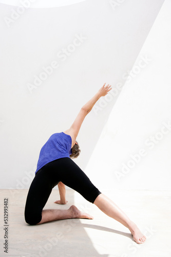 Middle aged senior yoga woman demonstrating asana for aging bodies.  photo