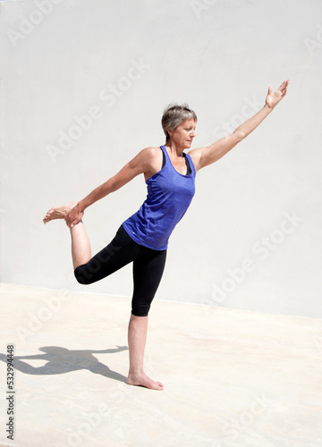 Middle aged senior yoga woman demonstrating asana for aging bodies.  photo