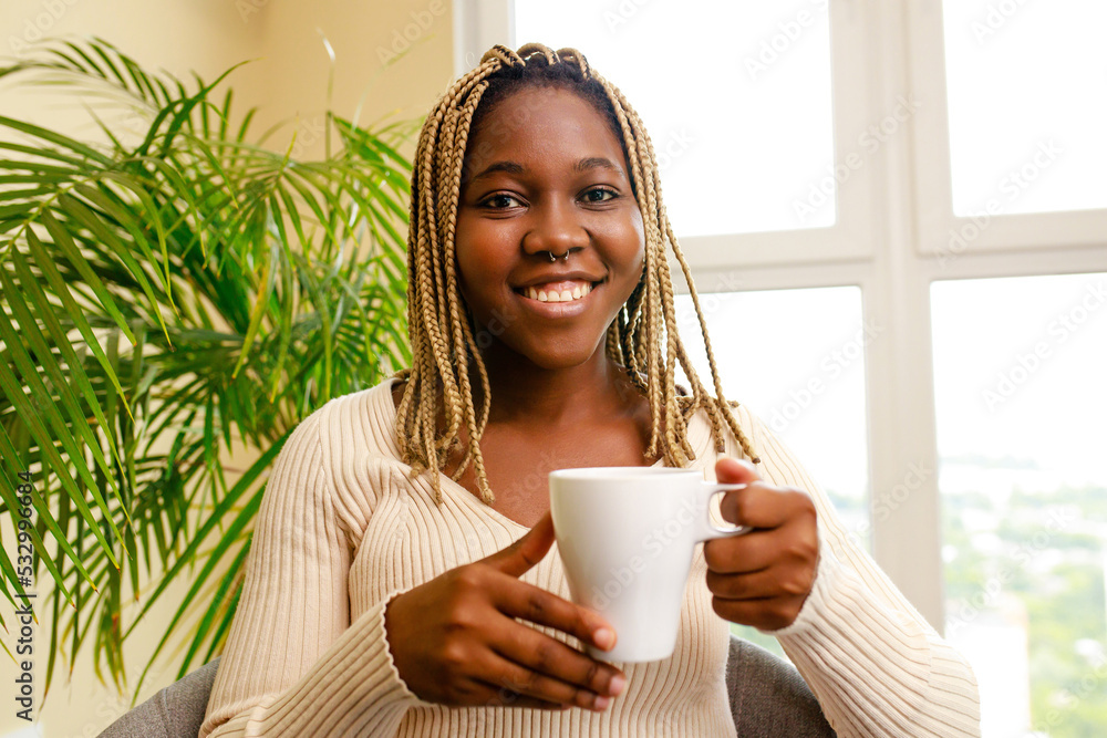 smiling brazilian woman relaxing at home with cup of tea smiling brazilian woman relaxing at home with cup of tea