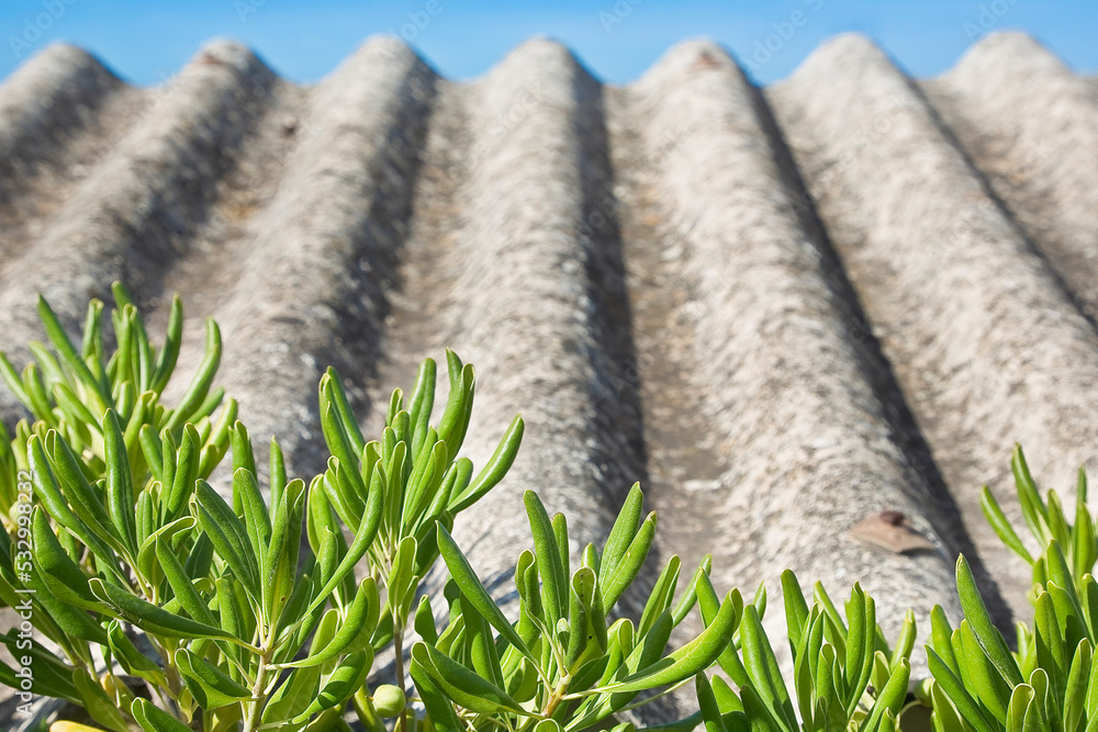 Old aged dangerous roof made of prefabricated corrugated asbestos