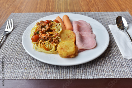 Mix food ham, sausage, potatp fried and spaghetti with tomato sauce in the one dish.  Is very nice  breakfast. photo