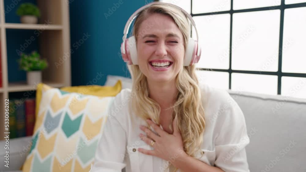 Young blonde woman wearing headphones smiling confident at home Young blonde woman wearing headphones smiling confident at home