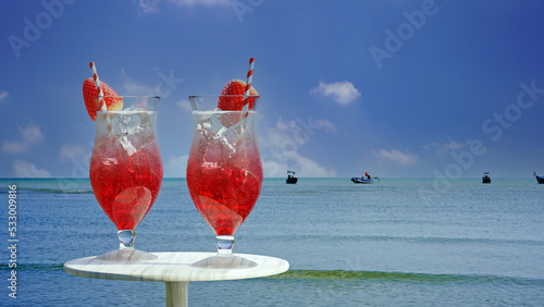 3D Couple of fresh red strawberry fruits juice in beautiful glass with water drop on glass and some strawberries sweet fruits on table blue sea and sky view background