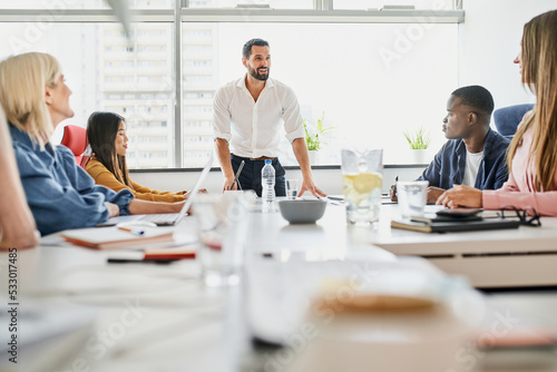 Business meeting. Male leader talking to group of diverse business people in office
