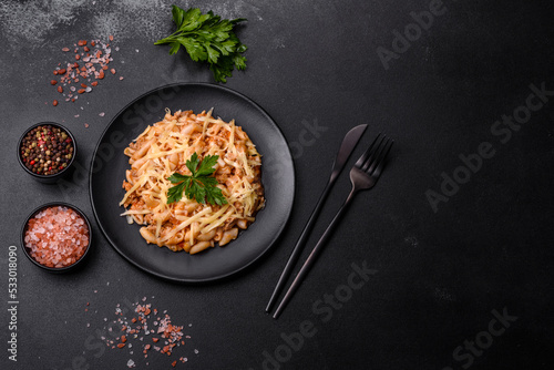 Tasty appetizing classic italian pasta with tomato sauce and cheese on plate on dark background