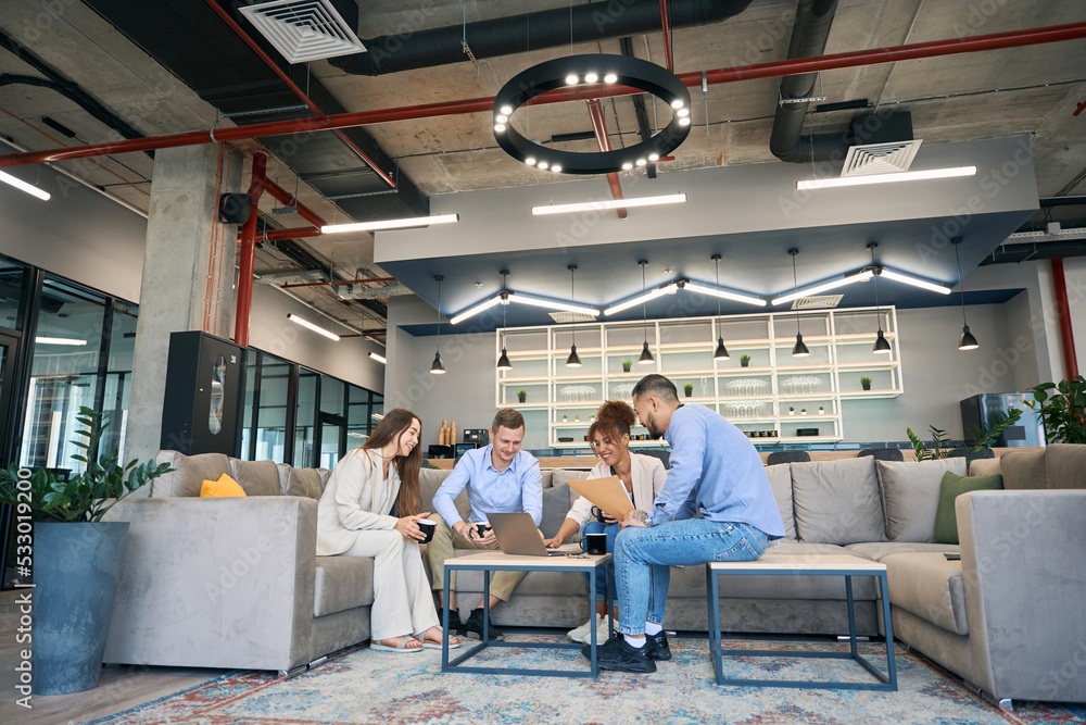 Businesspeople holding business meeting at coffee table in co-working space