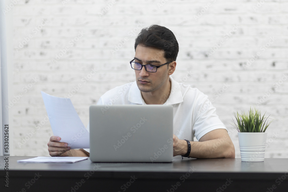 Serious businessman sitting at the table at home and working. Distant work concept Serious businessman sitting at the table at home and working. Distant work concept