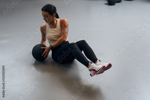 Fotografi Female doing side twist exercise with medicine ball during intense functional tr