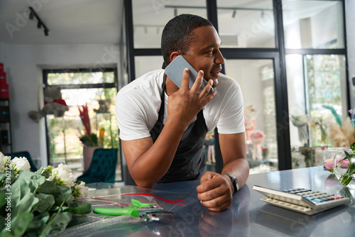 Принти на полотні African american worker talking on the phone in a flower shop