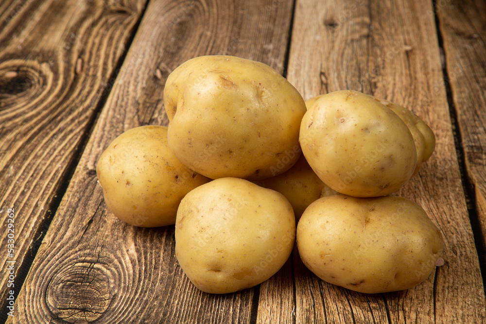 White potatoes on a wooden background.Fresh vegetables. Sale. White potatoes on a wooden background.Fresh vegetables. Sale.