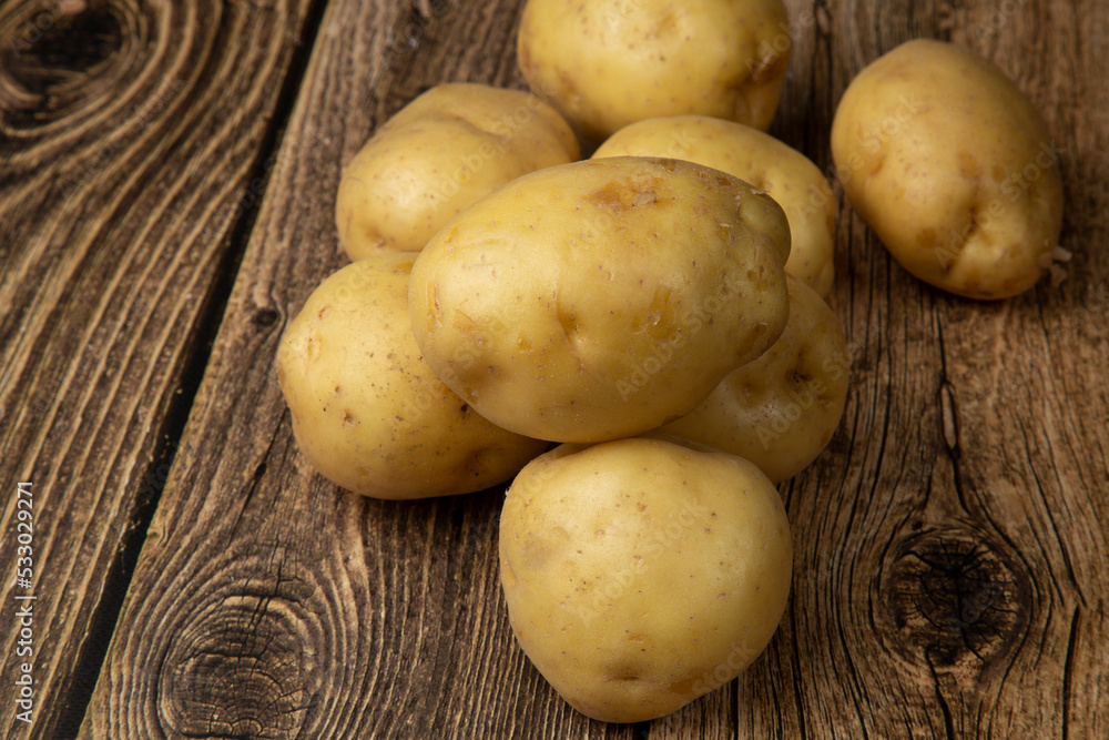 White potatoes on a wooden background.Fresh vegetables. Sale. White potatoes on a wooden background.Fresh vegetables. Sale.