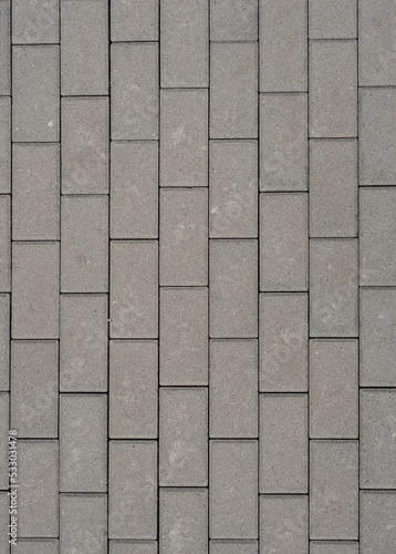 Grey concrete pavement with with rectangular plates for background. Front view with copy space.
