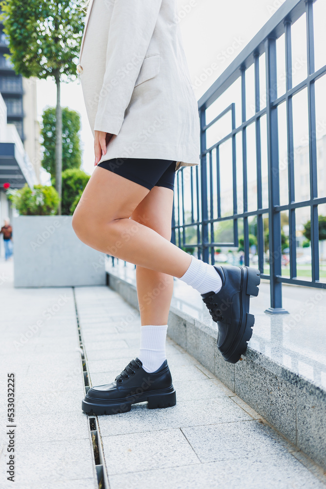 Female legs in leather shoes, white socks with and black moccasins, black  shorts, fashion details Stock Photo | Adobe Stock