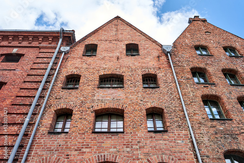 A facade with windows of a historic tenement house in the city of Torun