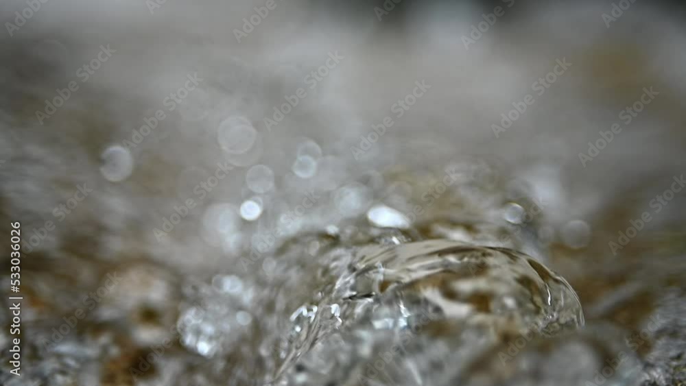Closeup of water at the top of a waterfall in the mountains (bokeh, slow motion) Closeup of water at the top of a waterfall in the mountains (bokeh, slow motion)
