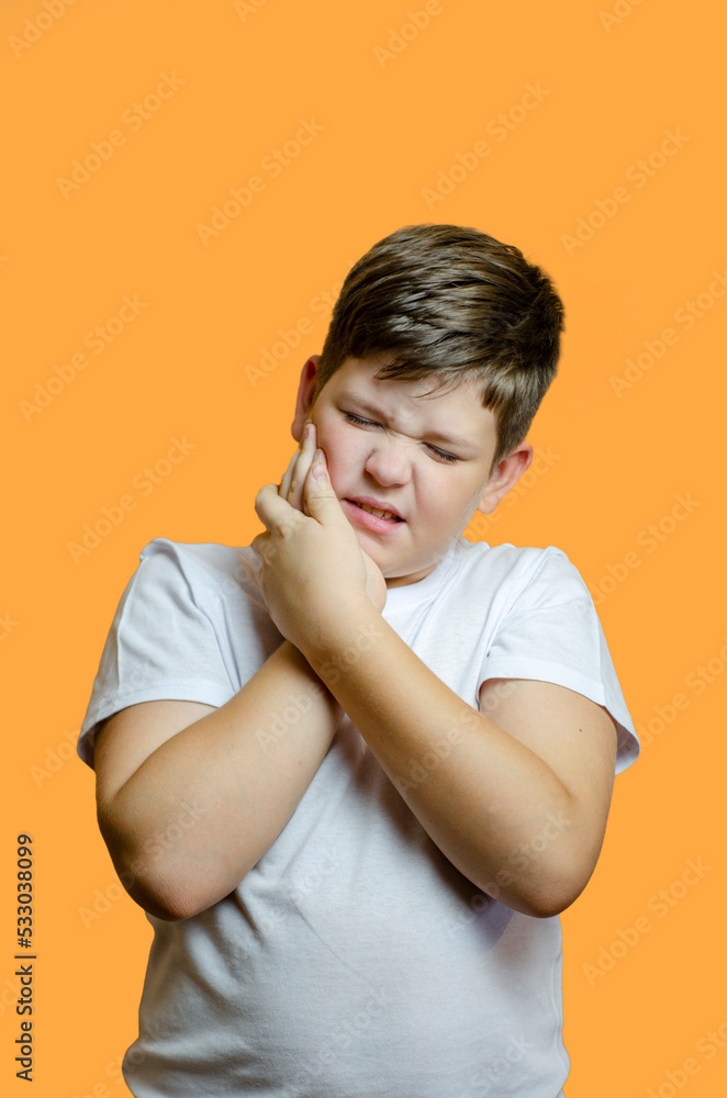 the child has a toothache, beautiful on a uniform background in a white T-shirt without inscriptions, the emotion of sadness and pain the child has a toothache, beautiful on a uniform background in a white T-shirt without inscriptions, the emotion of sadness and pain