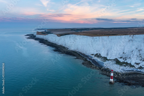 Epic vibrant Summer dawn landscape image of Beachy Head Lighthouse in South Downs National Park in England photo