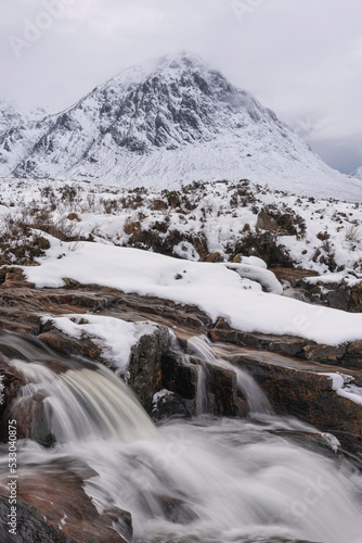 Majestic Winter landscape image of River Etive in foreground with iconic snowcapped Stob Dearg Buachaille Etive Mor mountain in the background © veneratio