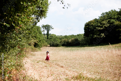 petite enfant fille marche dans la prairie en été © eloi
