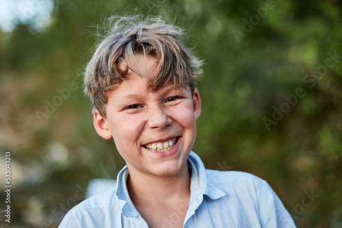 Portrait d'un ado garçon blonde en exterieur