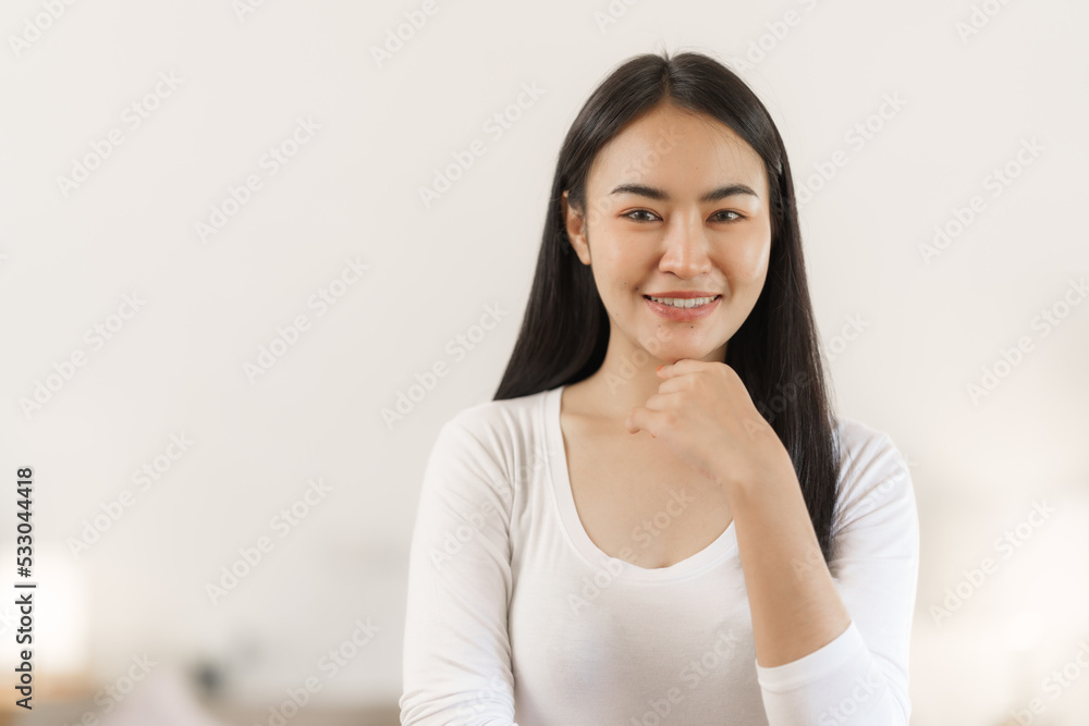 Confident smiling asian woman in creative home office looking at camera. Confident smiling asian woman in creative home office looking at camera.