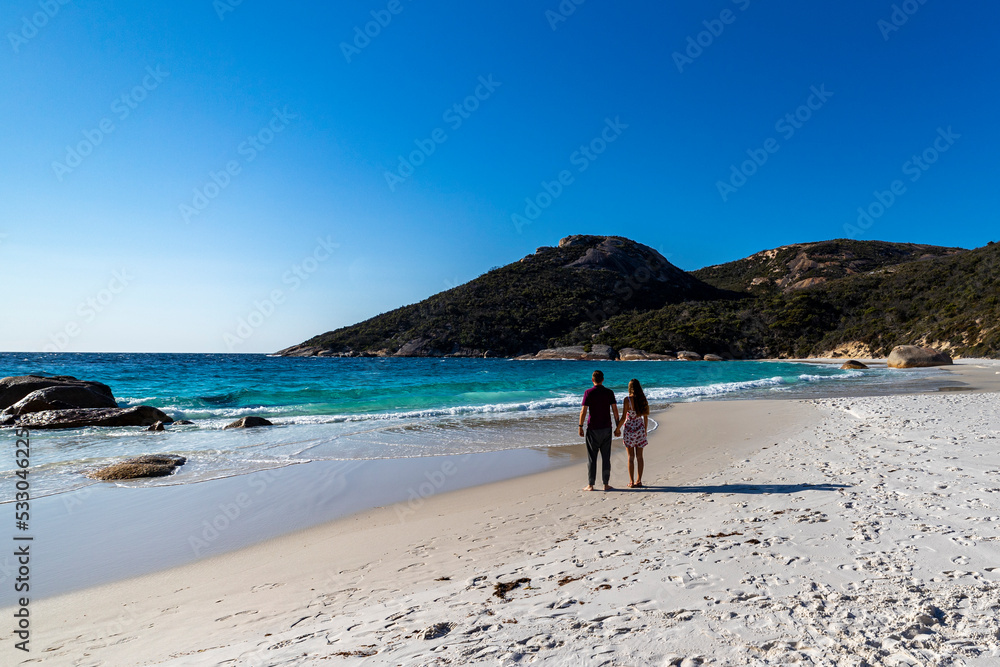 a couple holding hands walk on a paradise beach in western australia, two peoples bay