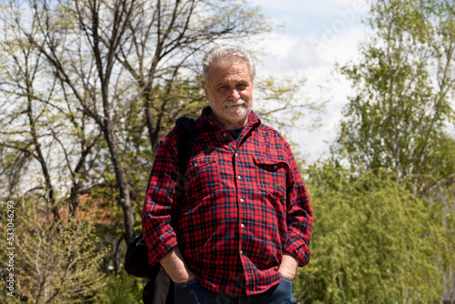 Elderly man is walking among the nature 