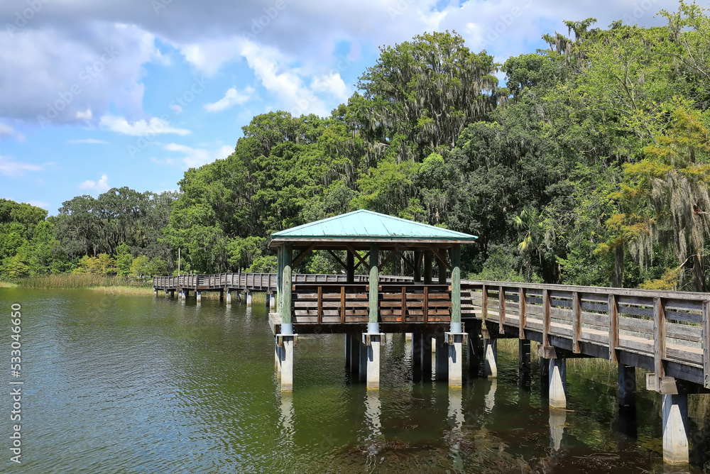 Picnic pavilion and boardwalk at Palm Island Park in Mount Dora, Florida. Palm Island Park is dog friendly with an 8 acres nature preserve trails and a fishing pier. Picnic pavilion and boardwalk at Palm Island Park in Mount Dora, Florida. Palm Island Park is dog friendly with an 8 acres nature preserve trails and a fishing pier.