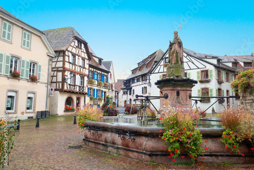 view of the historic town square of Eguisheim, a popular tourist destination along the famous Alsace Wine Route, on a sunny day with blue sky, Alsace-Champagne-Ardenne-Lorraine, France