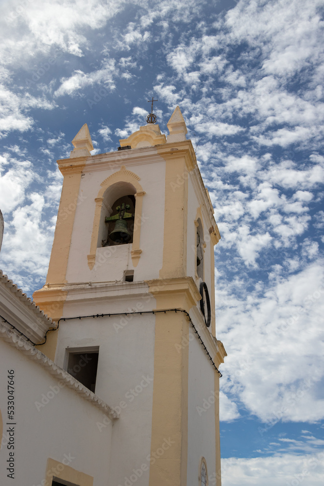 Church bell tower under beautiful blue cloudy sky, Algarve, Portugal