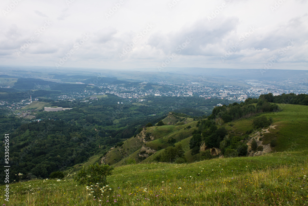 Panoramic top view of a beautiful valley with trees and hills and a blurred horizon against a cloudy dramatic sky in Kislovodsk russia Panoramic top view of a beautiful valley with trees and hills and a blurred horizon against a cloudy dramatic sky in Kislovodsk russia