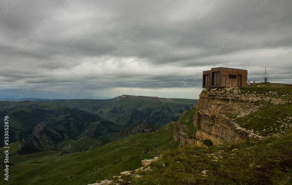 Panoramic view of green mountains and hills from the Bermamyt plateau in Karachay-Cherkessia in Russia on a cloudy summer day and a copy space