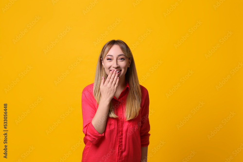 Beautiful young woman laughing on yellow background. Funny joke Beautiful young woman laughing on yellow background. Funny joke